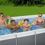 Bestway Stahlrahmenpool mit Familie im Garten. Eckiger Pool mit grauem Rahmen und Poolleiter.