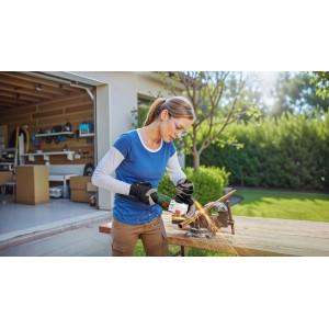 Frau schleift Metallrohr mit Bosch Akku-Winkelschleifer PWS 18V-70. Funken fliegen.