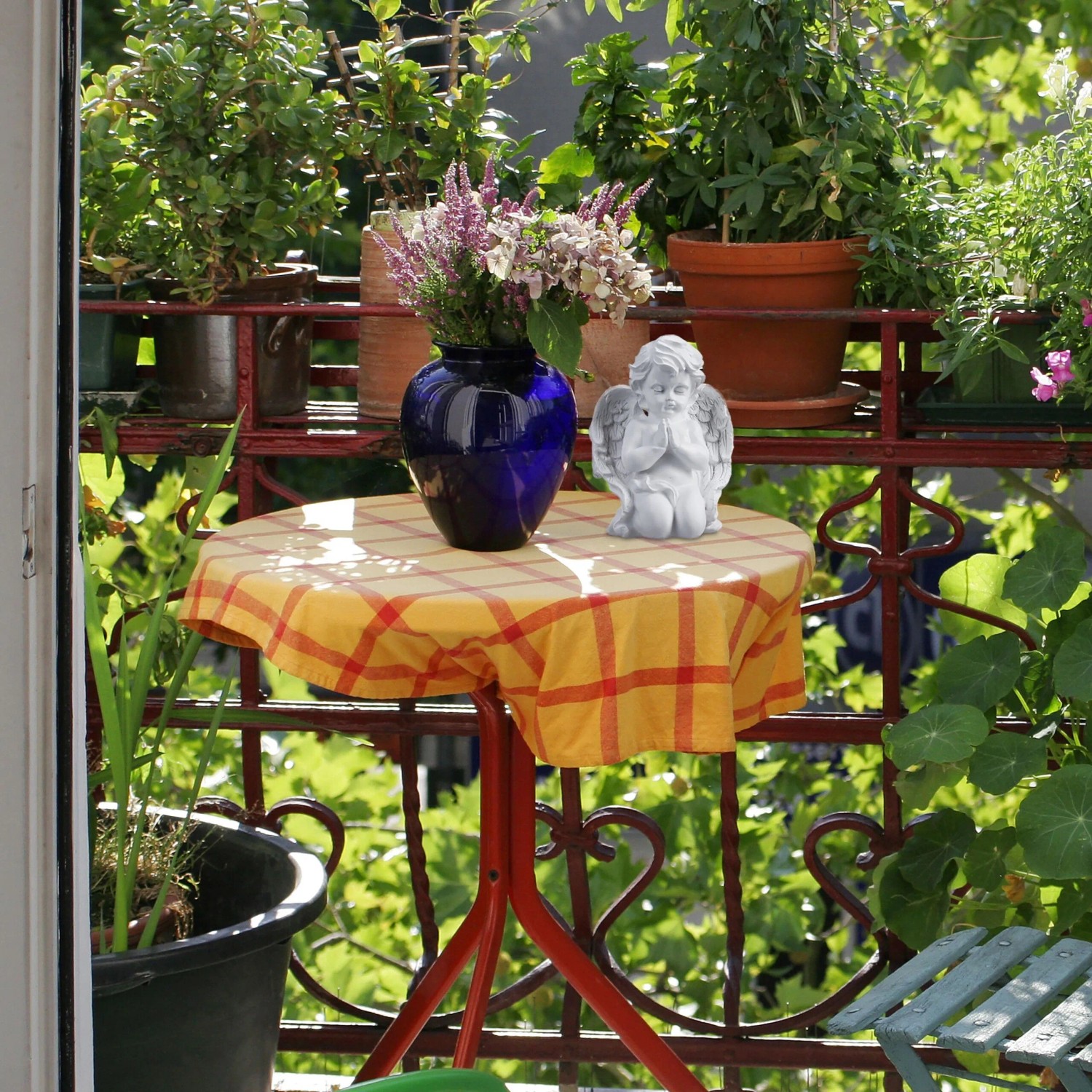 Weißer Relaxdays Grabengel aus Polyresin, kniend mit betenden Händen, als Dekofigur auf einem Balkontisch.