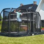 Schwarzes Salta Premium Ground Trampolin 305x214 cm mit springendem Kind im Garten.