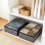 Graue Unterbettkommoden mit transparentem Deckel im Kleiderschrank, gefüllt mit Kleidung. Praktische textile Aufbewahrung.