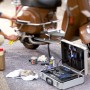 Abdeckvlies schützt Boden bei Reparatur eines Rollers mit Werkzeugkoffer und Zubehör.