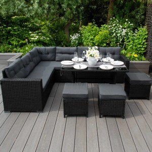 Schwarzes Polyrattan Gartenmöbel Set mit Ecksofa, Tisch und Hockern im Garten.