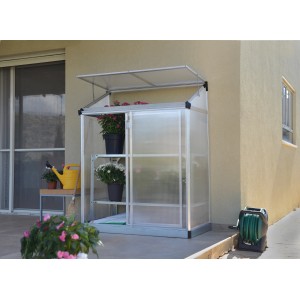 Palram Canopia Minigewächshaus Lean To, 125x64 cm, silber, an Hauswand mit Pflanzen.