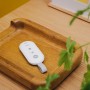 Weiße Yale Fernbedienung zur Alarmschaltung auf Holztablett. Kabellose Steuerung für Smart Alarm Systeme.