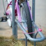 Pinkes Fahrrad mit Fahrradschloss am Fahrradständer. Kabelschloss mit Schlüssel.