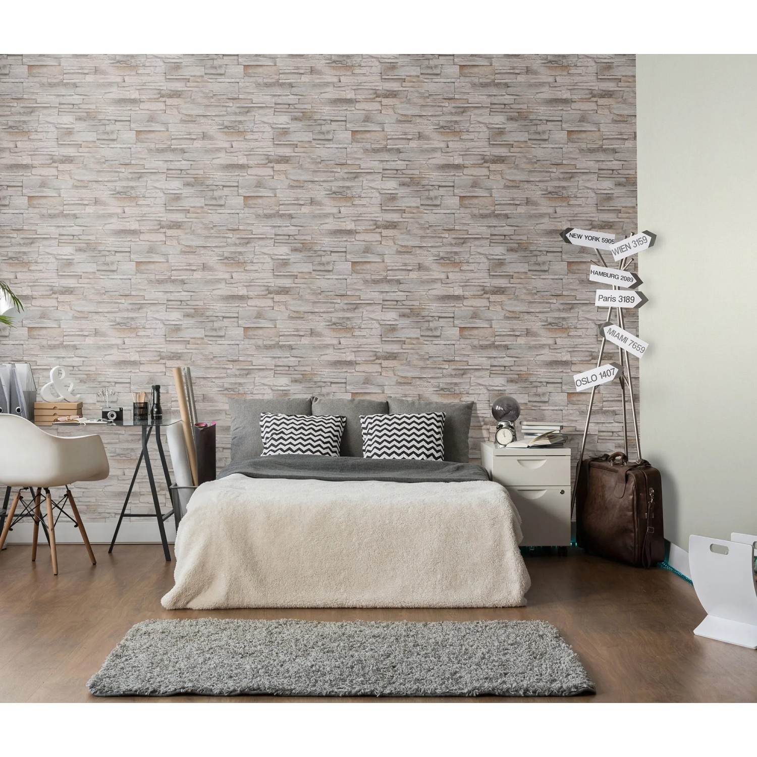 Beige Vliestapete „Stones Klein“ von Erismann imitiert eine Steinwand im Schlafzimmer.