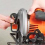 Black+Decker Handkreissäge CS1550 in Aktion, orange-schwarz, mit Sägeblatt. Hand führt Säge.