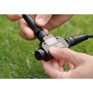 Philips Hue Outdoor T-Stecker in der Hand, Zubehör für smarte Gartenbeleuchtung.