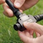 Philips Hue Outdoor T-Stecker in der Hand, Zubehör für smarte Gartenbeleuchtung.
