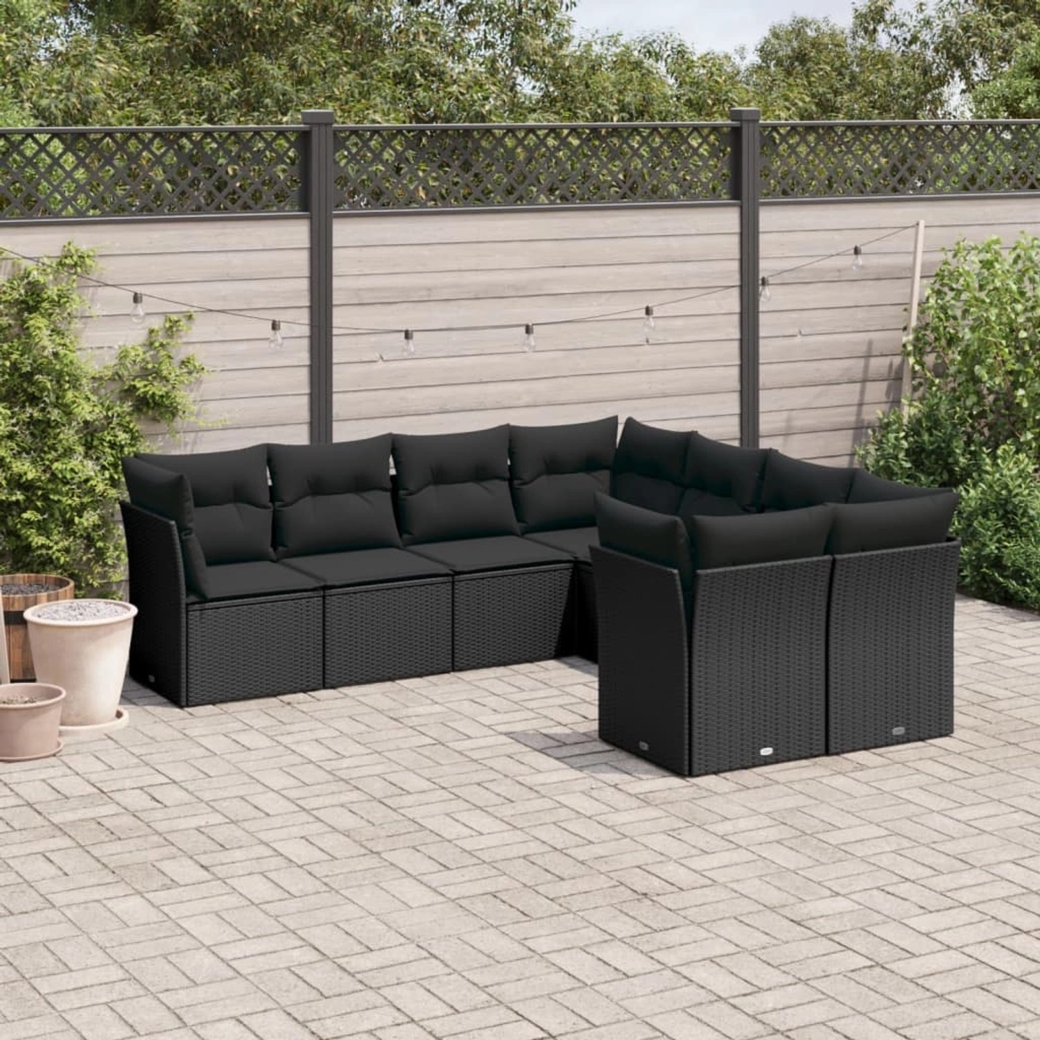 Schwarze 8-tlg. vidaXL Garten-Sofagarnitur aus Polyrattan mit Kissen auf einer Terrasse.