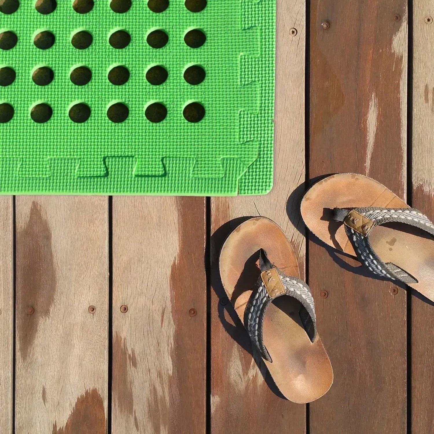 Grüne eyepower Poolmatte (8er Set, 62x62 cm) neben Sandalen auf Holzdeck – ideal als Poolfolie.