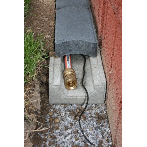 Grauer Kabel- und Schlauchkanal mit Schlauch und Kabel, eingebettet in Einfassung.