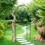 Schwarzer Stahl Rosenbogen als Rankhilfe für Kletterpflanzen im Garten, mit pinken Blüten und Gartenweg.