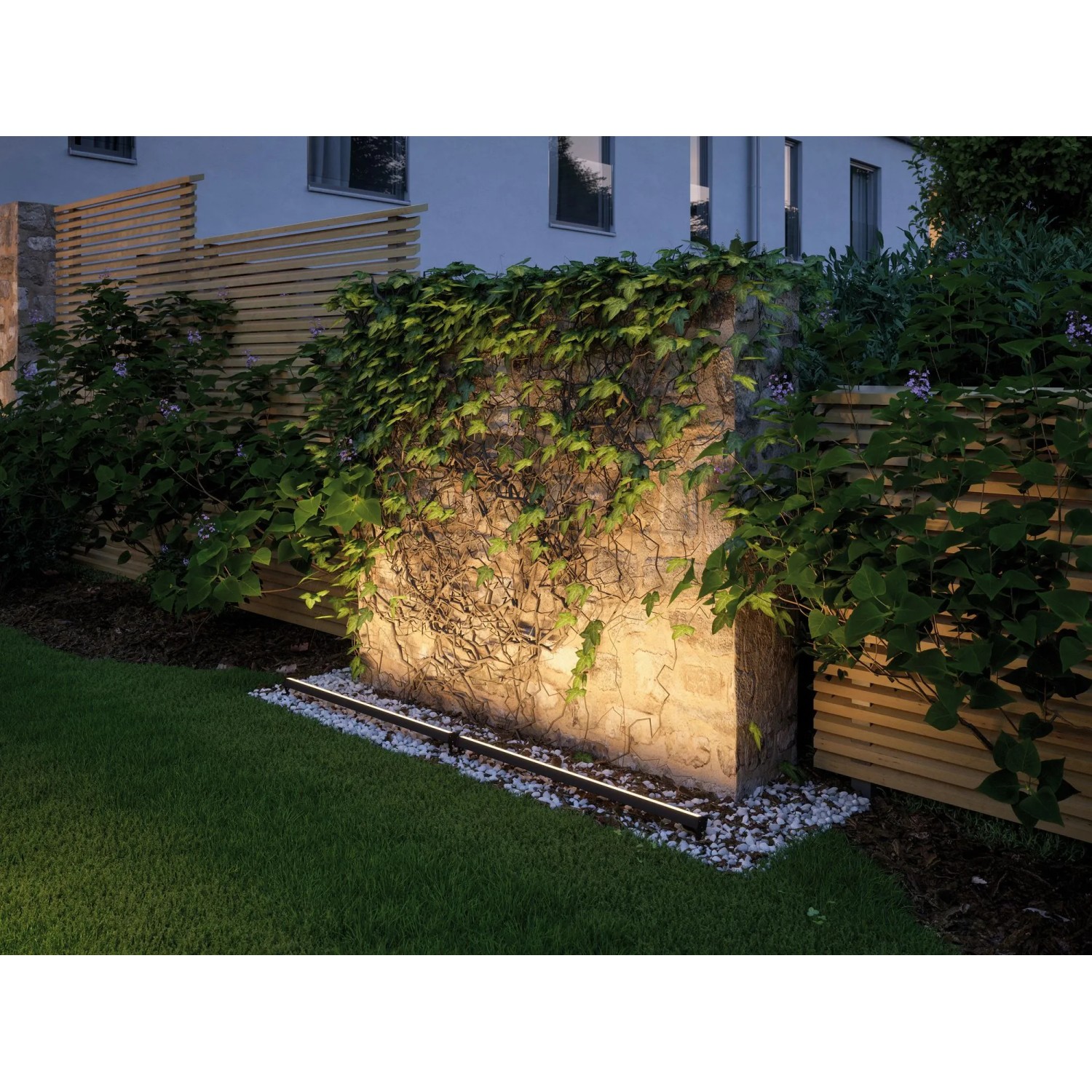 Paulmann Plug & Shine LED-Lichtleiste zur Beleuchtung einer Gartenmauer mit Efeu, warmweißes Licht.