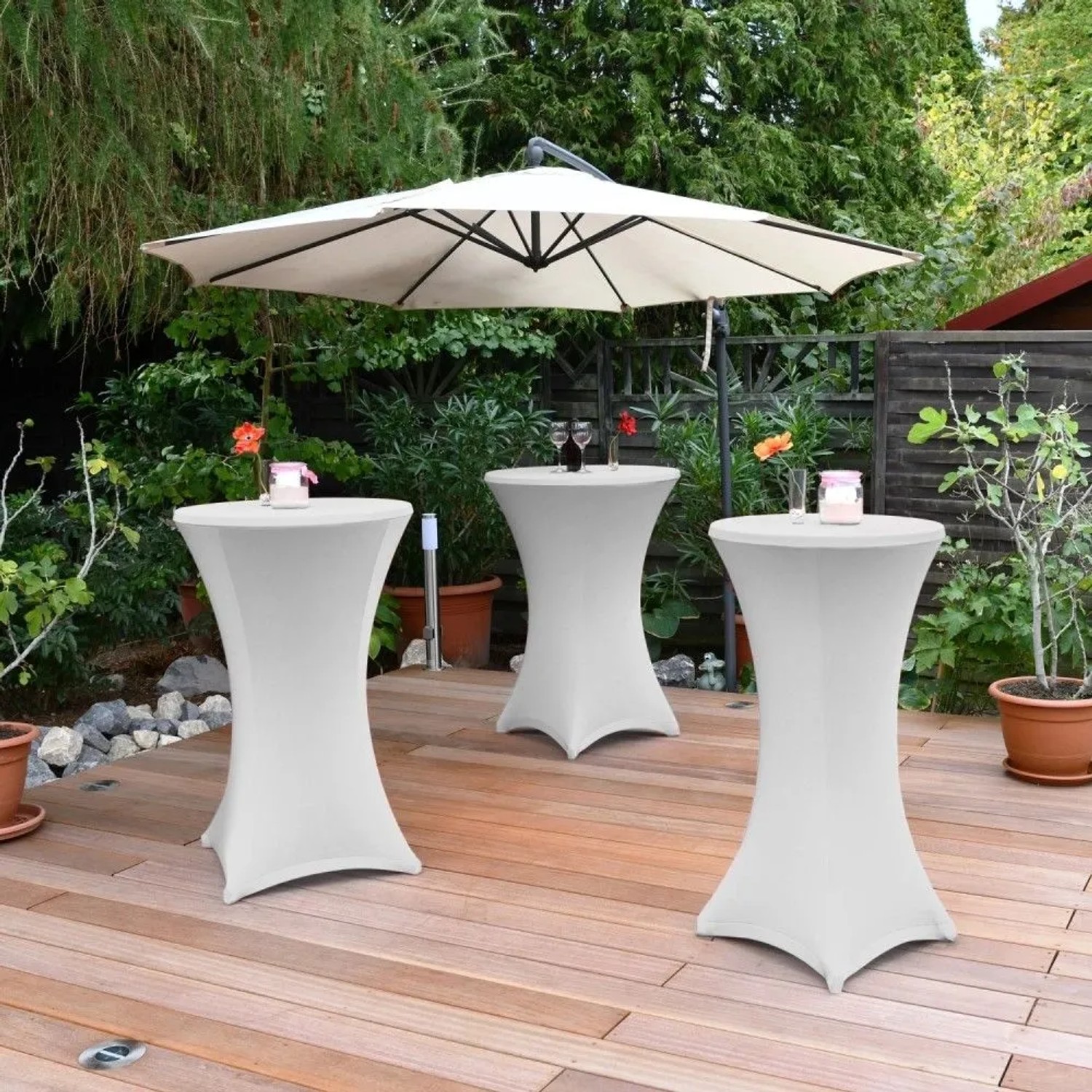 Weiße Stretch-Stehtischhusse für Ø 80 cm Tische auf Holzterrasse. Elegante, faltenfreie Passform für festliche Anlässe.