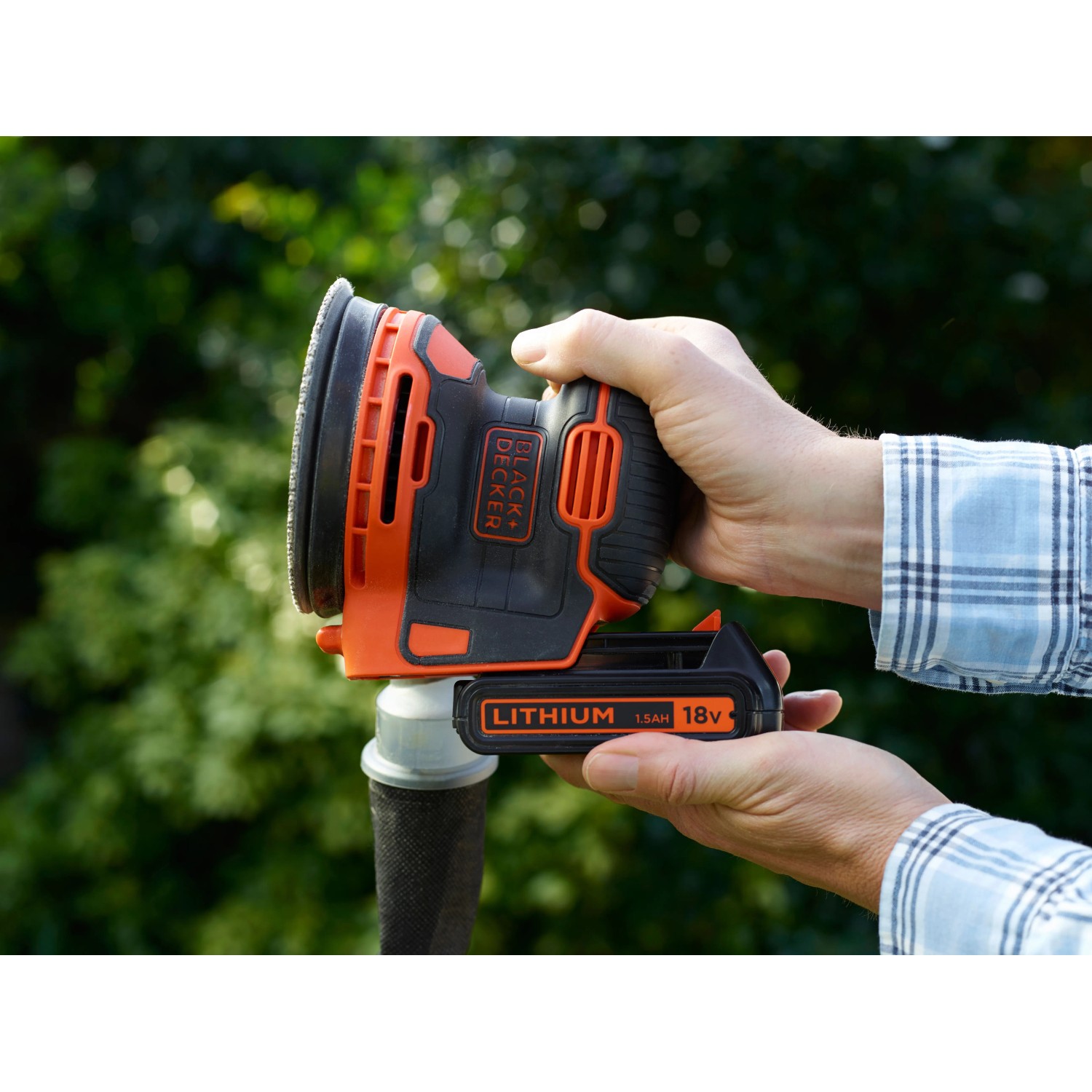 Black+Decker Akku-Exzenterschleifer BDCROS18 in Aktion, gehalten von Händen. Schleifmaschine mit Akku.