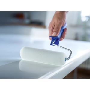 LUX Schaumwalze (16 cm) in Aktion: Hand führt Farbwalze über glatte, weiße Oberfläche.