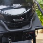 Schwarzer Char-Broil Elektrogrill Patio Bistro E2Coal mit Deckel, Thermometer und Bedienfeld. Dampf steigt auf.