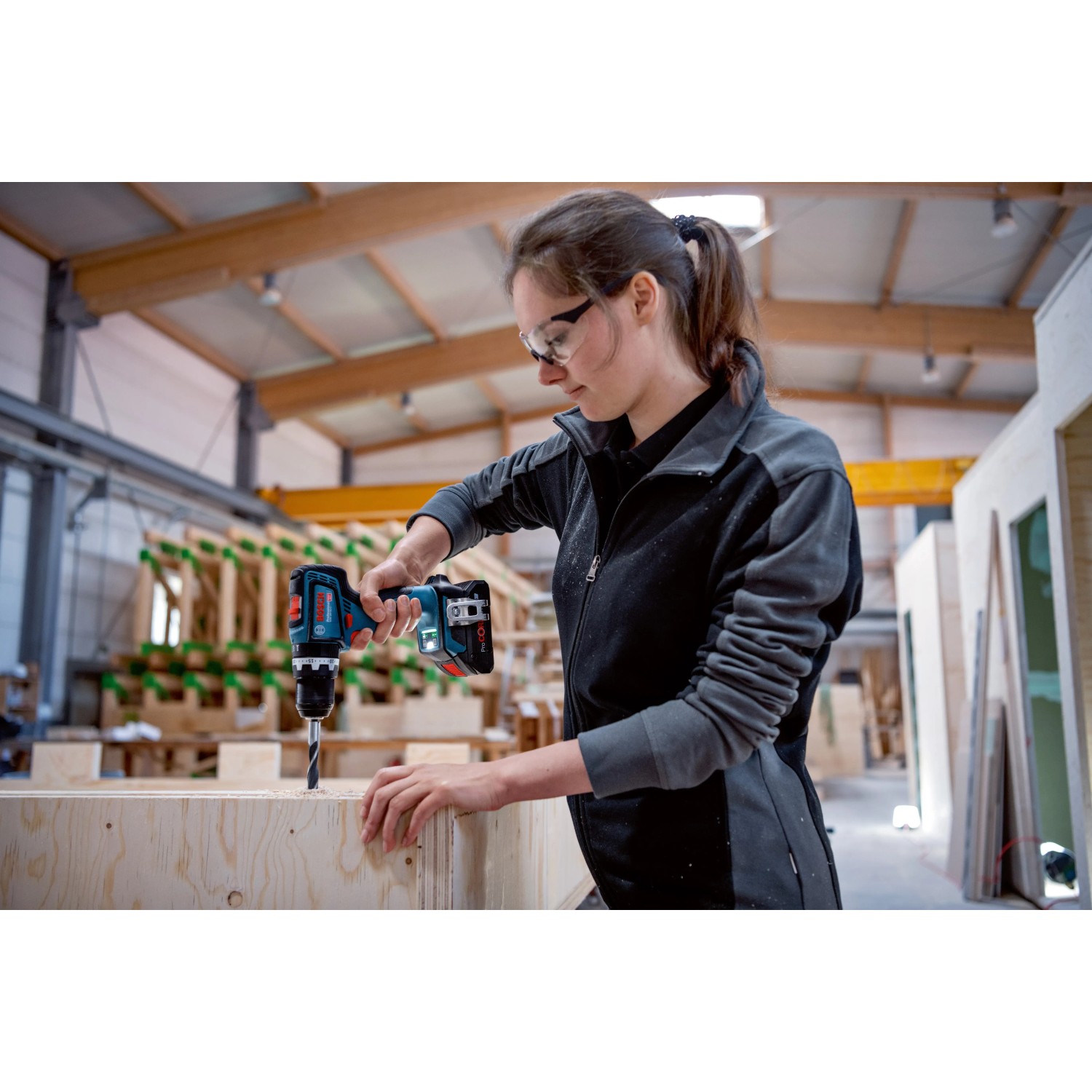 Frau bohrt mit Bosch Professional Akku-Schlagbohrschrauber GSB 18V-90 C in Holz.