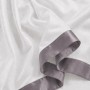 Weißes Baumwoll-Bettwäsche-Set Einzelbett mit dunkelgrauer Satin-Bordüre. Detailansicht des weichen Stoffes.