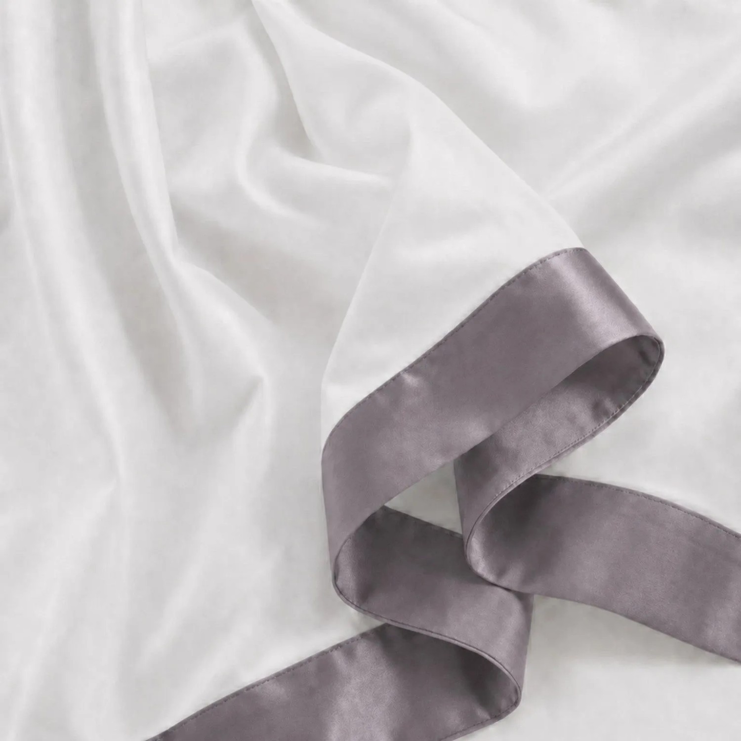 Weißes Baumwoll-Bettwäsche-Set Einzelbett mit dunkelgrauer Satin-Bordüre. Detailansicht des weichen Stoffes.