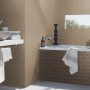 Badezimmer mit Rasch Vliestapete Factory IV 429299 in Mattgold. Dekorative Uni-Tapete im modernen Bad.