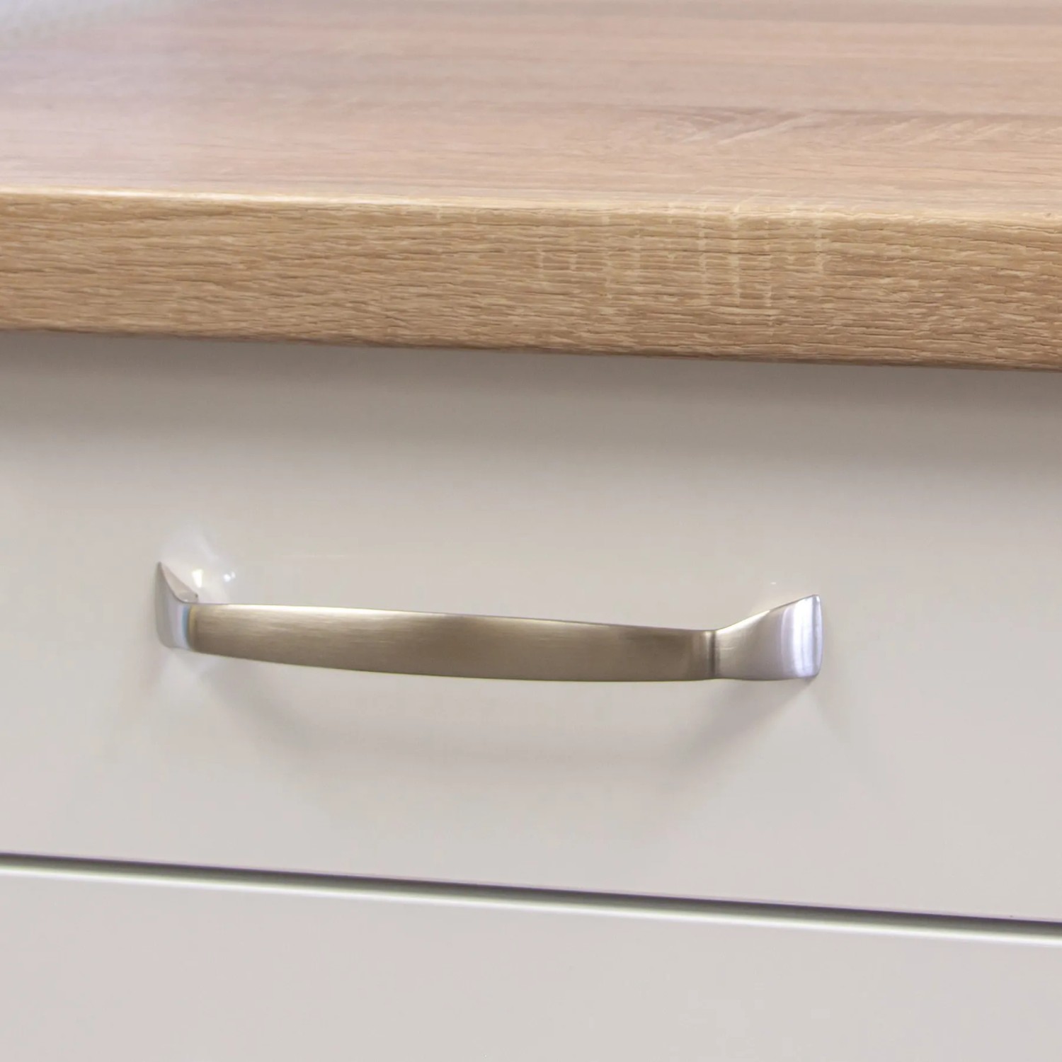 Detailaufnahme: Küchenzeile Valero in Weiß Hochglanz mit Arbeitsplatte in Sonoma Eiche und Griff.