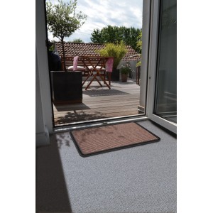Braune Astra Fußmatte Border Star (40x60 cm) vor einer Terrassentür. Schmutzfangmatte für den Innenbereich.
