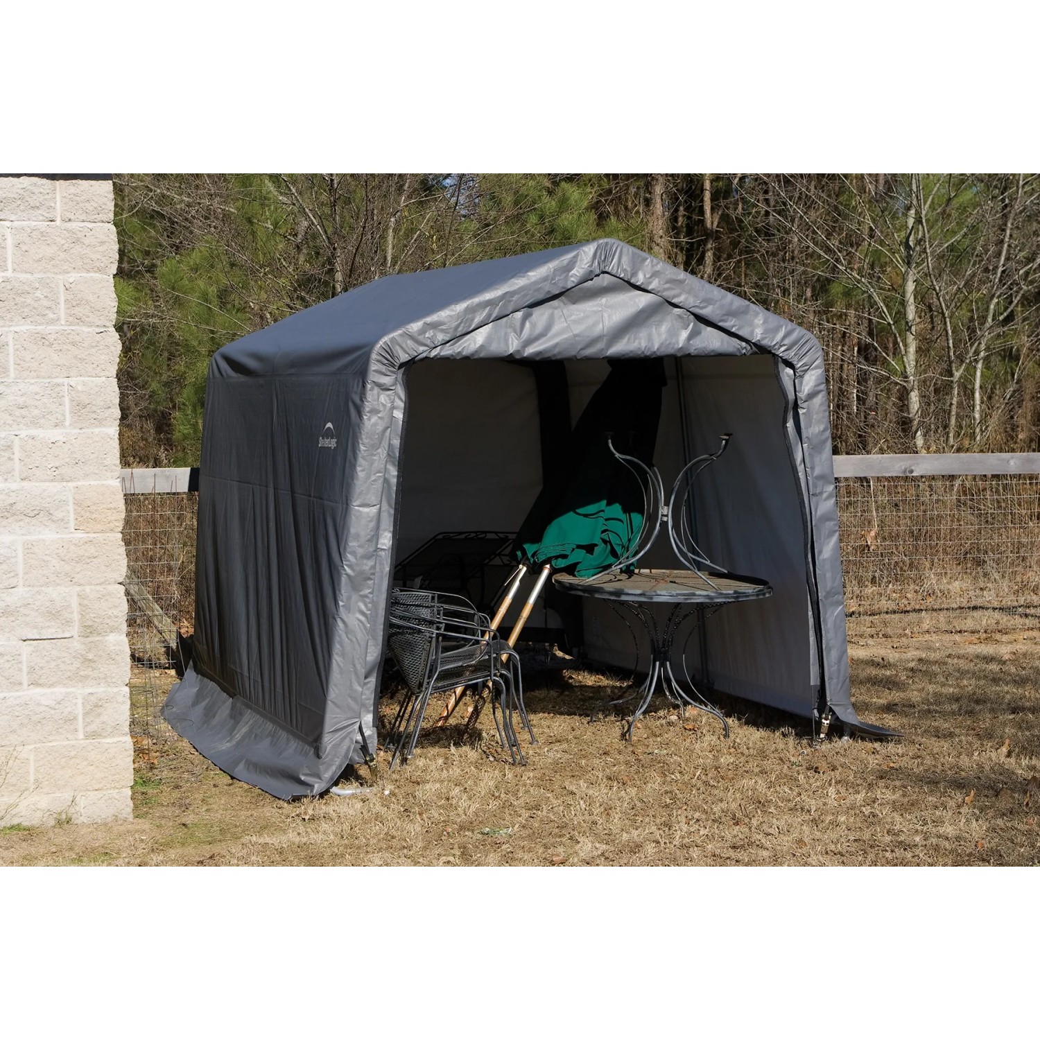 Graues Shelter Logic Metall-Gerätehaus 9 m² mit Gartentisch und Stühlen.
