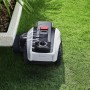 Ecovacs Mähroboter Goat O1200 in Weiß-Schwarz auf Rasenfläche, neben Beet.