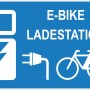 Blaues Warnschild: E-Bike Ladestation mit Symbolen für Ladung und Fahrrad.