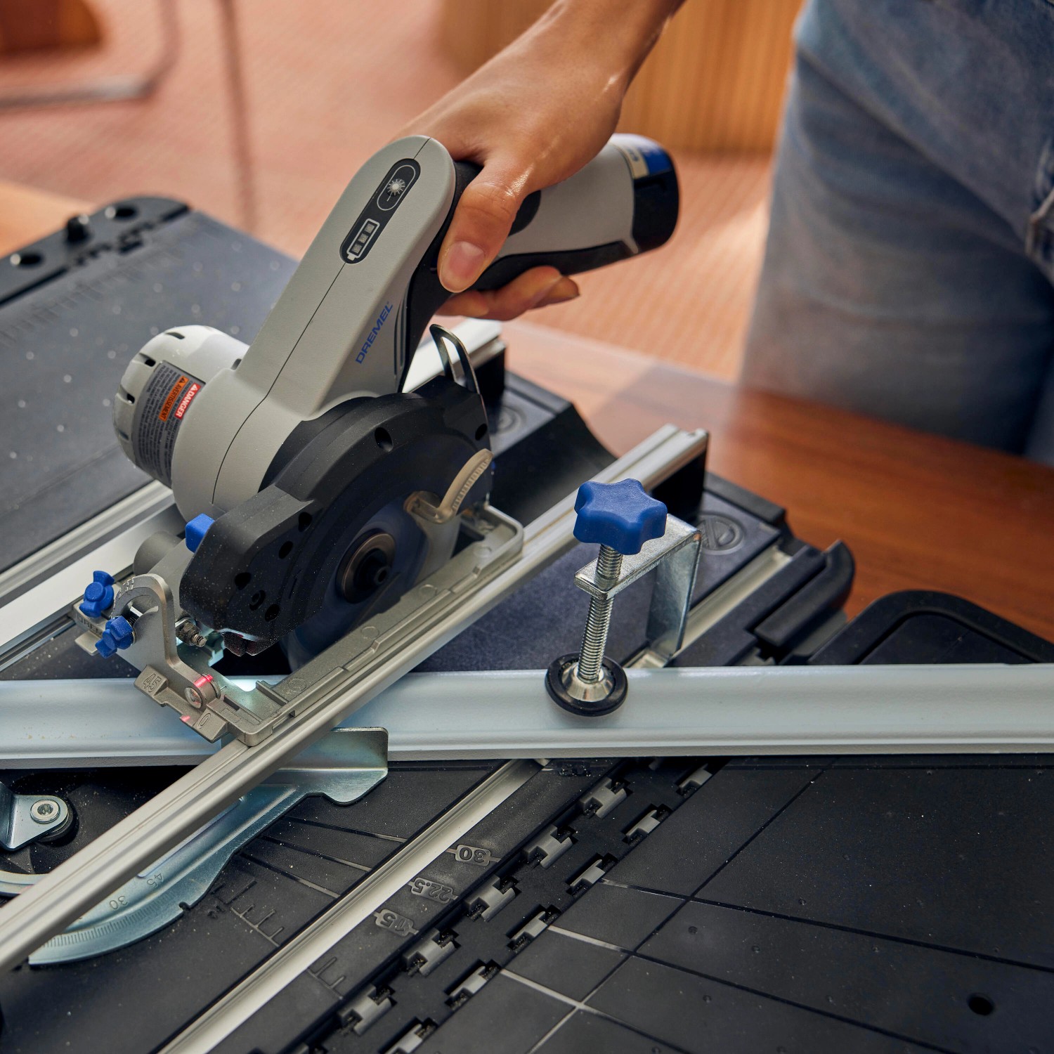 Dremel Kreissäge CS12V-S1C mit Sägetisch-Koffer beim Zuschnitt eines Werkstücks.