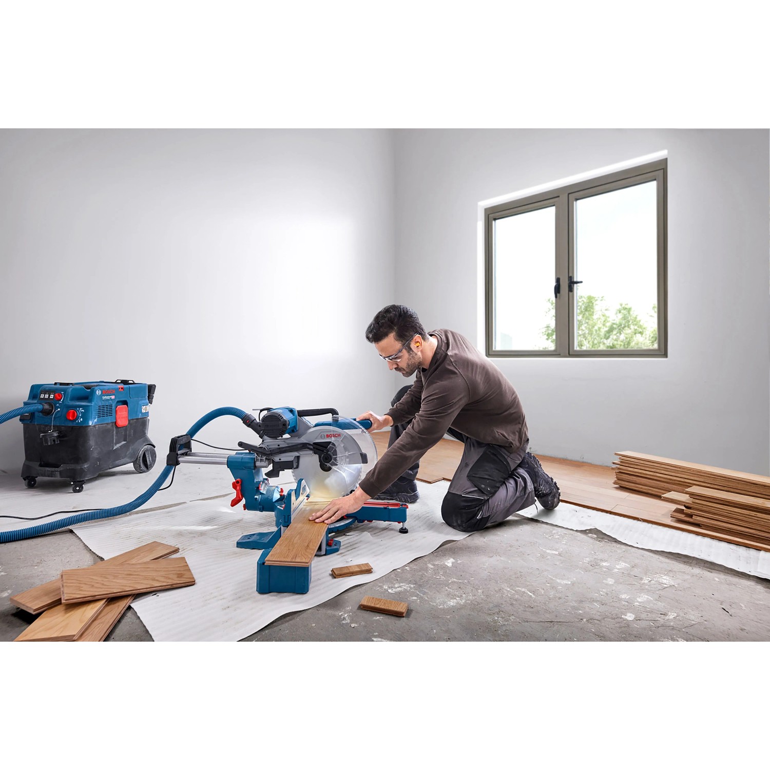 Mann schneidet Holz mit Bosch Professional Kapp- und Gehrungssäge GCM 340-305 D. Blaue Säge mit Staubabsaugung für präzise Schnitte.