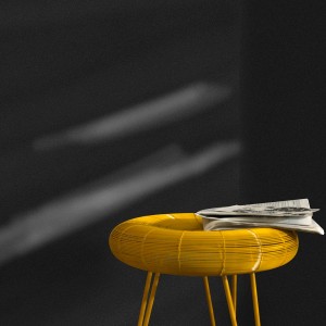 Nahaufnahme der schwarzen Bricoflor Uni Vliestapete mit Glitzer, kombiniert mit einem gelben Beistelltisch.