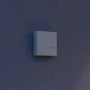 Weißer Steinel Dämmerungsschalter NightmatiQ an grauer Wand. Bewegungsmelder für Außenbeleuchtung.