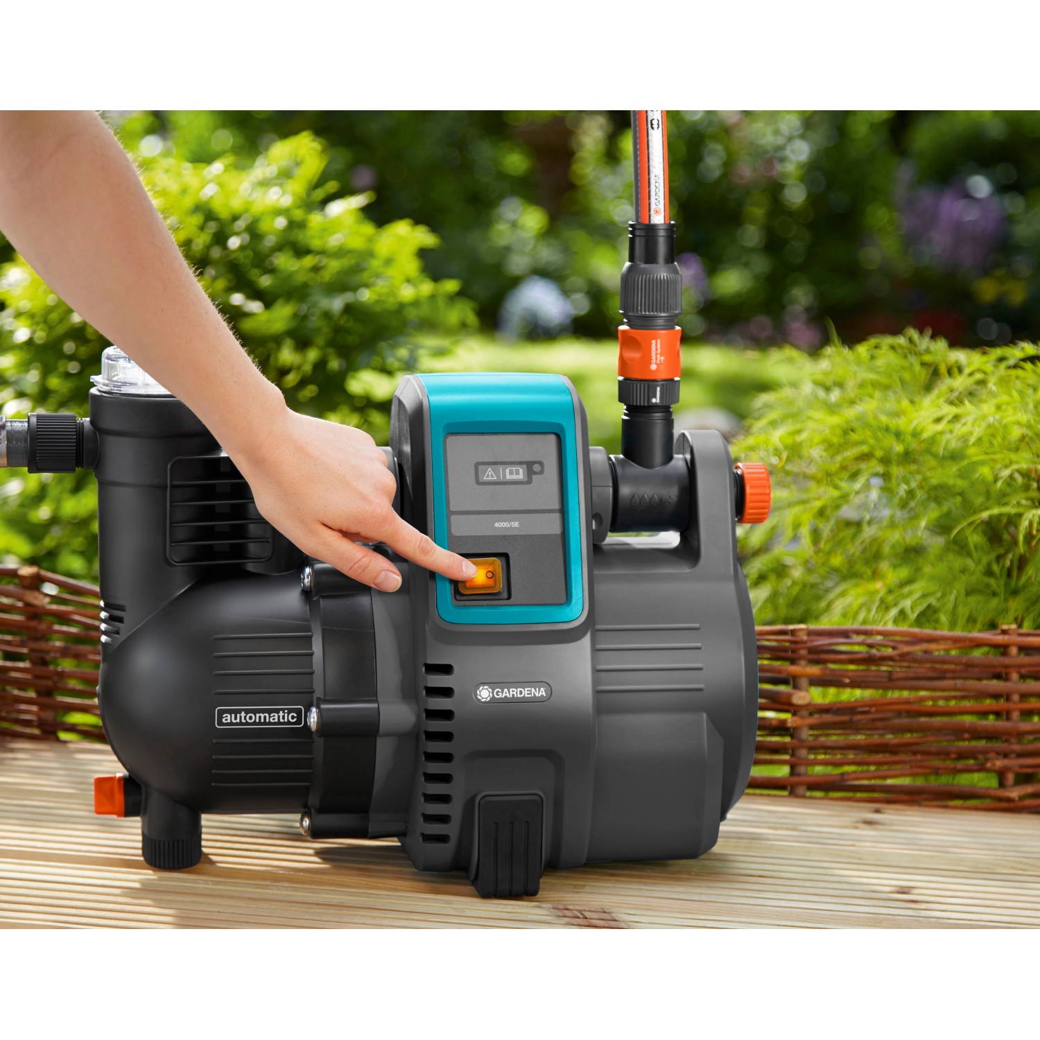Gardena Haus- und Gartenautomat 4000/5 in Aktion: Hand betätigt den Startknopf der Pumpe.