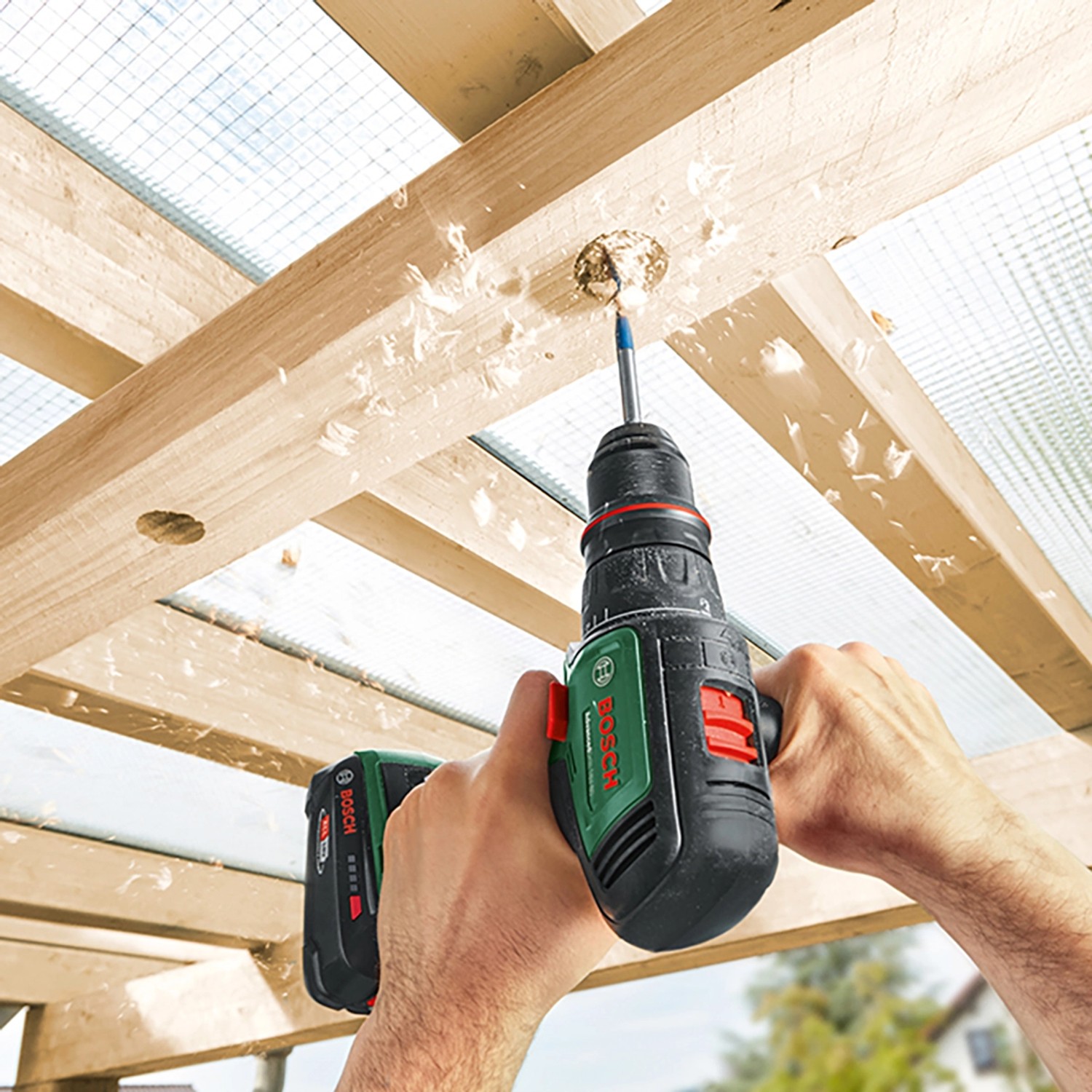 Bosch Advanced Drill 18 V-80 Akku-Bohrschrauber beim Bohren in Holz. Späne fliegen.