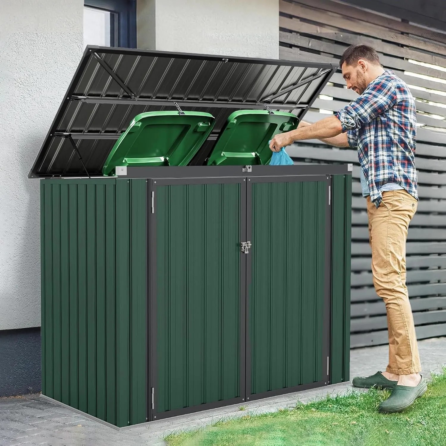 Grüne Metall-Mülltonnenbox für 2 Mülltonnen mit offenem Klappdeckel. Robuster Stauraum für den Außenbereich.