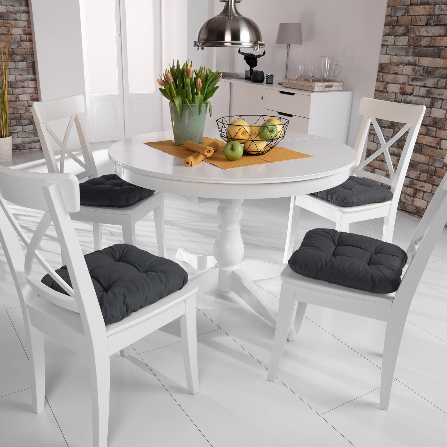 4er Set Beautissu Lisa Stuhlkissen 40x40 Anthrazit auf weißen Stühlen am Esstisch.