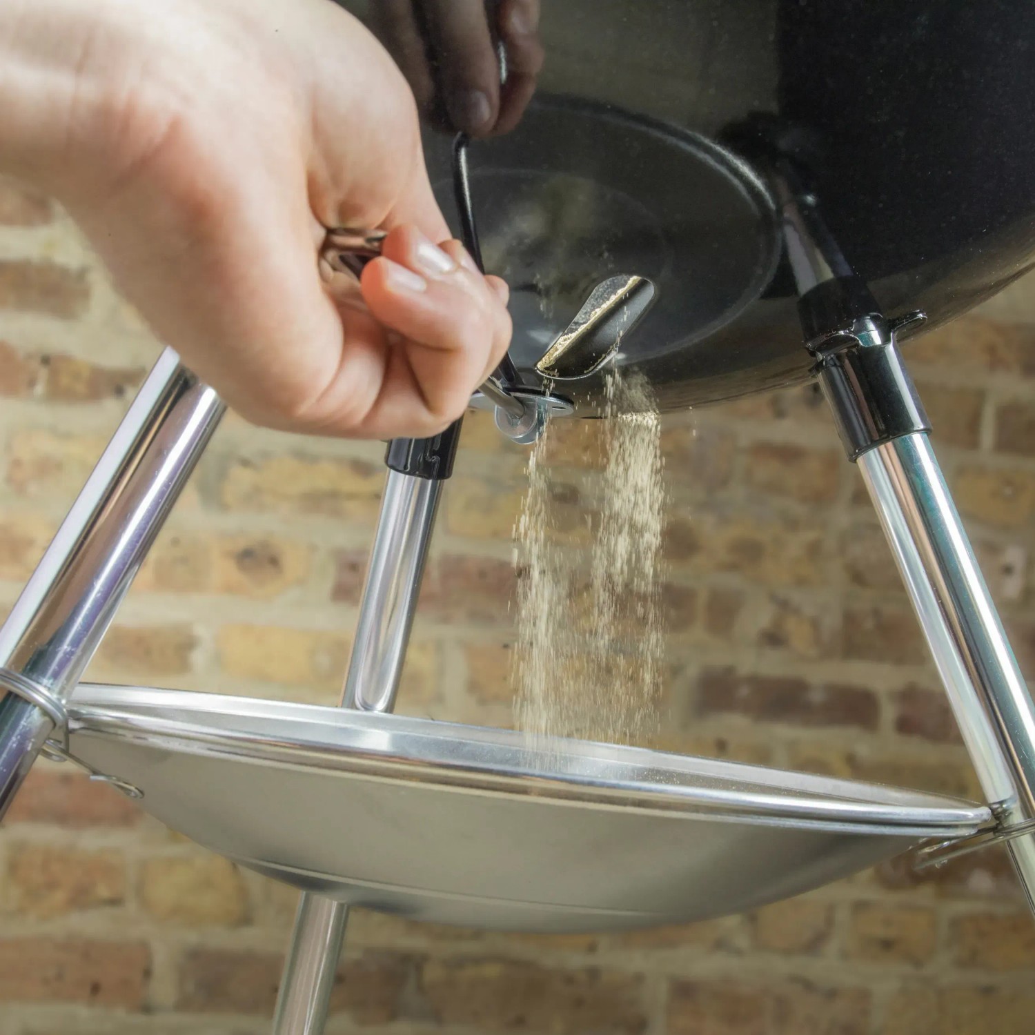 Weber Holzkohle-Kugelgrill Classic Kettle: Asche wird in die Auffangschale gekehrt.