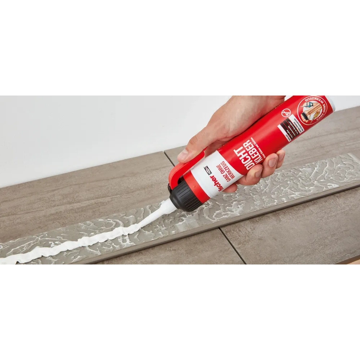 Anwendung von Fischer Dicht Kleber aus Kartusche auf Fliesen.