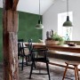 Wohnraum mit dunkelgrüner ESTAhome Vliestapete mit großen Blättern. Dekorative Tapete sorgt für Dschungel-Atmosphäre.