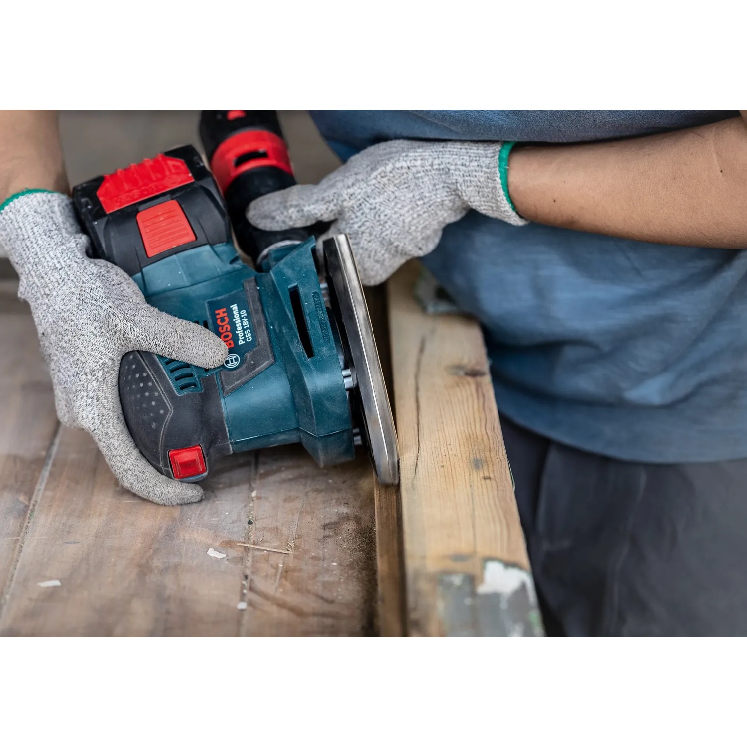 Bosch Schwingschleifer mit Schleifblatt beim Schleifen von Holz.