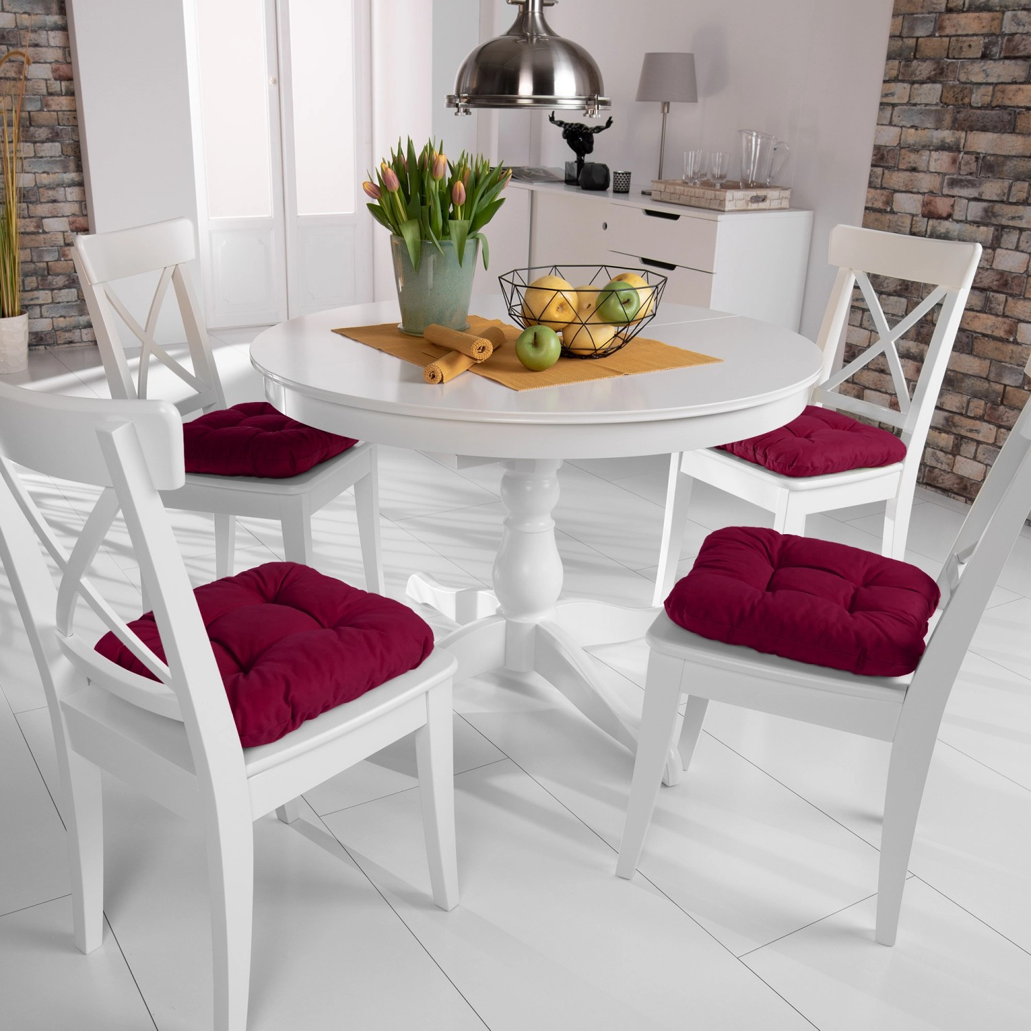 Vier rote Beautissu Lisa Stuhlkissen 40x40 auf weißen Stühlen am Esstisch.