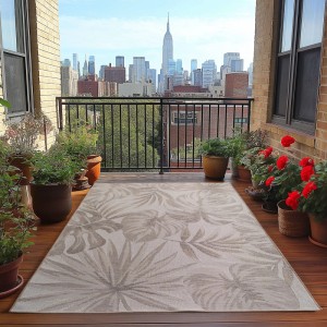Ayyildiz Outdoor-Teppich Desert Beige mit Pflanzenmuster auf Balkon mit Skyline.