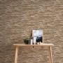 A.S. Création Tapete Stein-Optik in Braun und Beige an Wand hinter Holztisch.