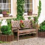 Flexible Weiden-Beeteinfassung als runde Abgrenzung für ein Pflanzenbeet im Garten, neben einer Holzbank. Ideal als Rasenkante.