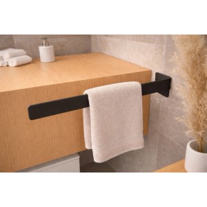 Schwarzer Radius Design Handtuchhalter für Bad, klebend an Holzschrank. Modernes Design, platzsparend, mit Handtuch.