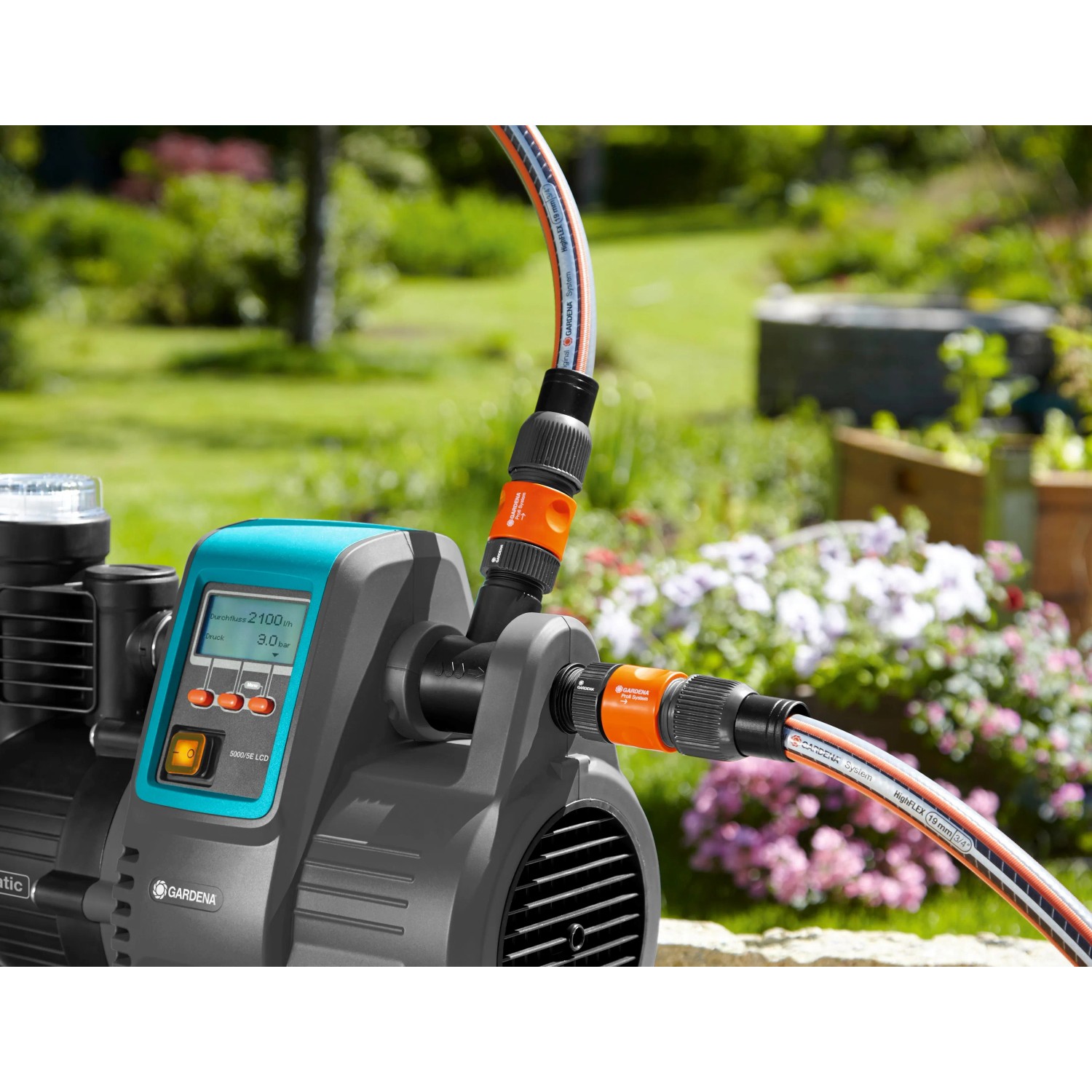 Gardena Garten- und Hauswasserautomat 5000/5 LCD mit angeschlossenen Gartenschläuchen im Einsatz.